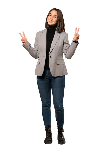 Повнометражний знімок молодої ділової жінки, яка посміхається і показує знак перемоги обома руками над ізольованим білим тлом
 - Фото, зображення