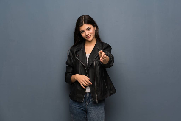 Tizenéves lány egy jó üzlet lezárásának kezet rázott, szürke falon - Fotó, kép