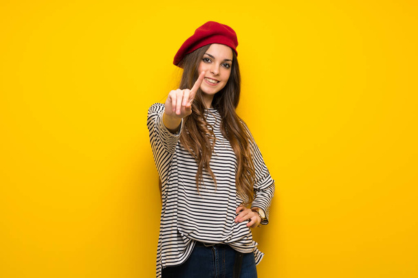 Kızla Fransız tarzı gösteren ve parmak kaldırma sarı duvardan - Fotoğraf, Görsel