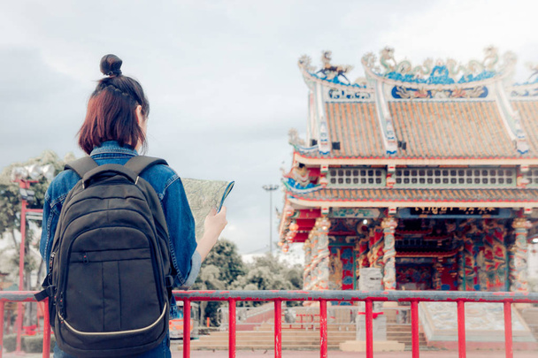 turistické dívka drží mapu a při pohledu na pohled umístění cestování kulturní a usmívá se na celodenní výlet - Fotografie, Obrázek