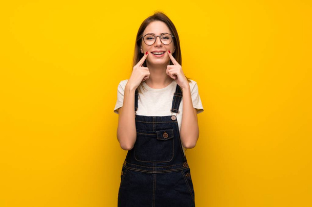 Woman over yellow wall smiling with a happy and pleasant expression - Photo, Image