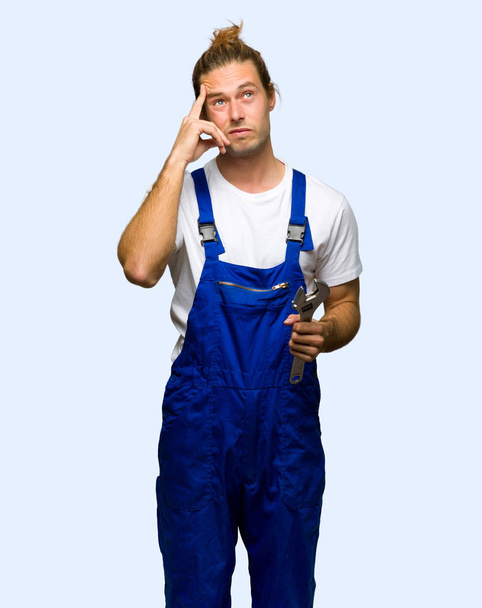 Workman having doubts and thinking on isolated background - Foto, Bild