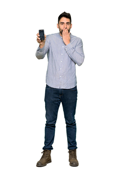 Sorunlu holding smartphone izole beyaz arka plan üzerinde kırık ile gömlek ile zarif adamın tam uzunlukta atış - Fotoğraf, Görsel