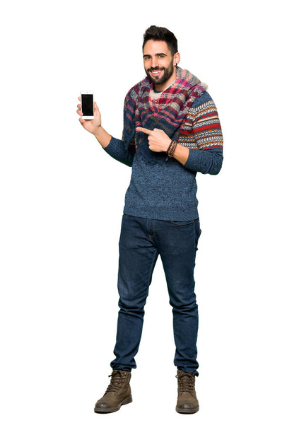 Full-length colpo di Hippie uomo felice e puntando il cellulare su sfondo bianco isolato
 - Foto, immagini