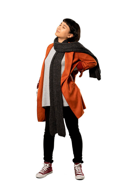 A full-length shot of a Short hair woman with coat suffering from backache for having made an effort over isolated white background - Foto, afbeelding