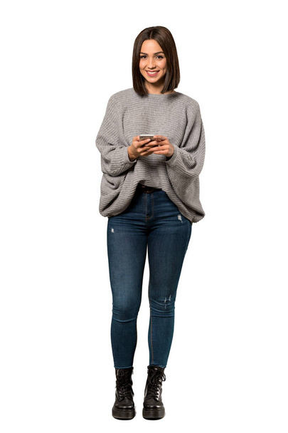 Полнометражный снимок молодой женщины, отправляющей сообщение с мобильного на изолированном белом фоне
 - Фото, изображение