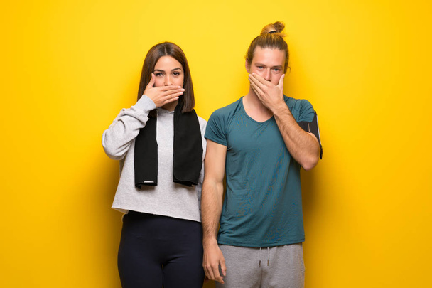 Group of athletes over yellow background covering mouth with hands for saying something inappropriate - Photo, Image