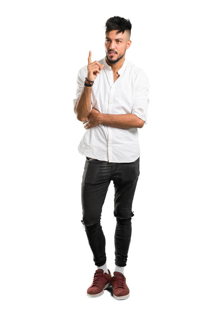 Повнометражний знімок арабського юнака з білою сорочкою, що вказує на вказівний палець, чудова ідея про ізольоване біле тло. - Фото, зображення