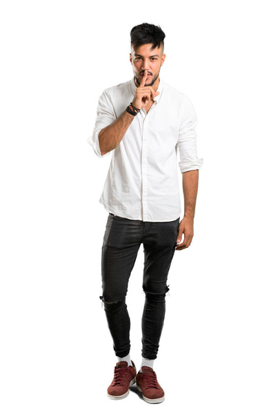 A full-length shot of a Arabic young man with white shirt showing a sign of closing mouth and silence gesture on isolated white background - Fotó, kép