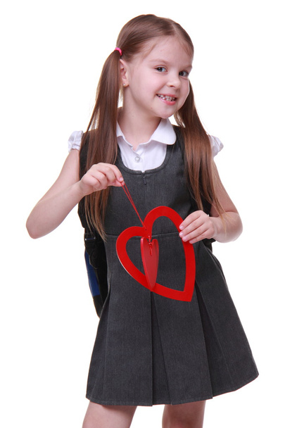 Caucasian lovely schoolgirl holding red heart symbol - Zdjęcie, obraz