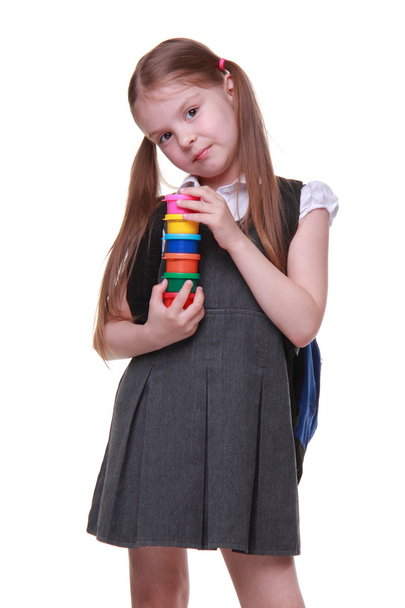 Cute schoolgirl in dress holding paints - Fotó, kép