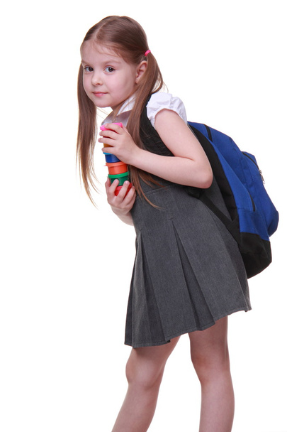 Cute schoolgirl with schoolbag holding paints - Fotó, kép