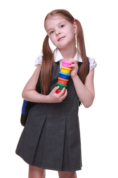 Cute schoolgirl in dress holding paints - Фото, зображення