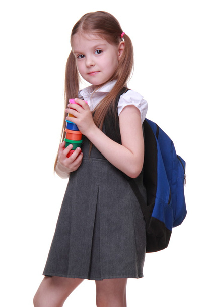 Cute schoolgirl with schoolbag holding paints - Foto, Bild