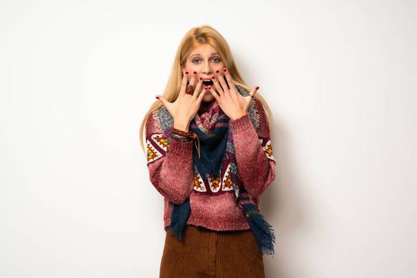 Mujer hippie sobre pared blanca con sorpresa y expresión facial impactada
 - Foto, imagen