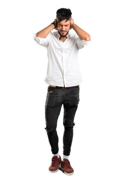A full-length shot of a Arabic young man with white shirt covering both ears with hands on isolated white background - Foto, immagini