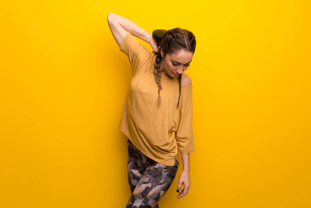 Sport woman on vibrant yellow background making weightlifting - Foto, imagen