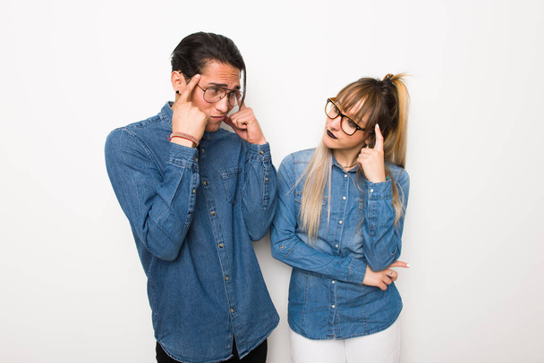 Mladý pár s brýlemi s pochybnostmi a přemýšleje - Fotografie, Obrázek