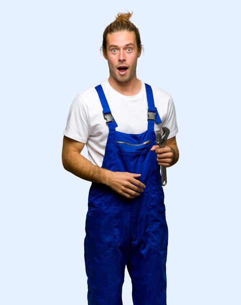 Workman with surprise and shocked facial expression on isolated background - Фото, изображение