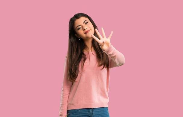 Tinédzser lány rózsaszín inget boldog és számolás négy ujjal elszigetelt rózsaszín háttér - Fotó, kép