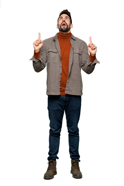 Full-length shot of Handsome man with beard surprised and pointing up on isolated white background - Photo, image