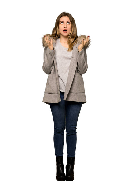A full-length shot of a Teenager girl with coat frustrated by a bad situation on isolated white background - Foto, imagen