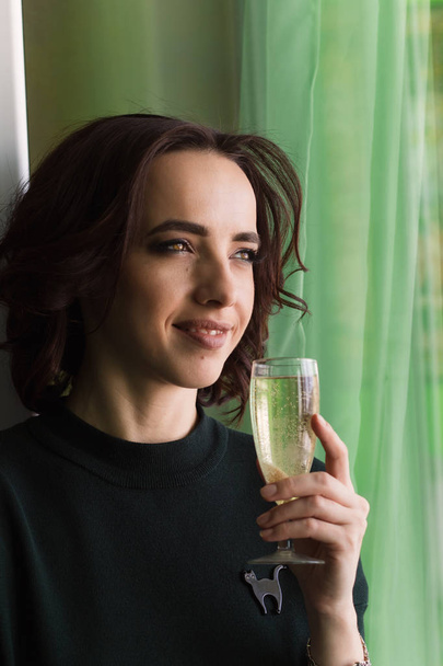 young beautiful brunette with a glass of sparkling wine - 写真・画像