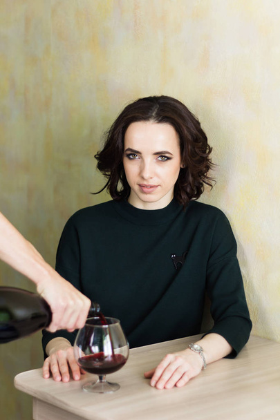 woman sitting at the table male hand pours wine in the glass - Foto, imagen