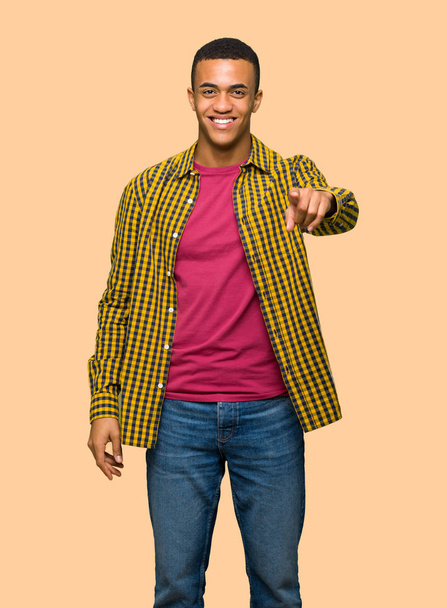 junger afroamerikanischer Mann zeigt mit selbstbewusstem Gesichtsausdruck auf isolierten Hintergrund - Foto, Bild