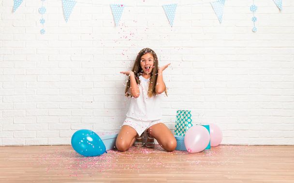 Little girl in a birthday party playing with confetti - Photo, Image
