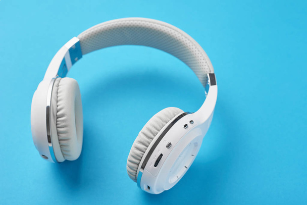 weiße drahtlose Kopfhörer auf pastellblauem Hintergrund - Foto, Bild