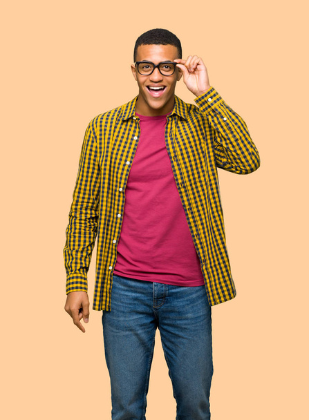 Jeune homme afro-américain avec des lunettes et surpris sur fond isolé
 - Photo, image