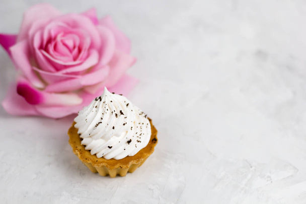 top view vanilla cupcake and blurred rose copy space - Φωτογραφία, εικόνα