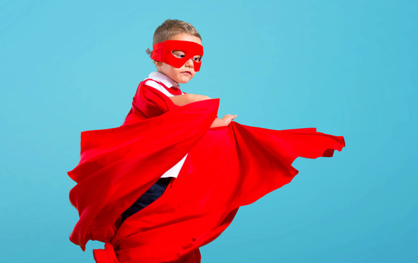Little kid dressed like superhero on color baackground - Foto, Bild