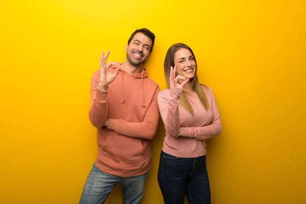 Két ember a sárga háttér mutatja az ok jele ujjaival csoportja - Fotó, kép