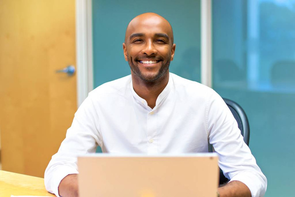 Boldog fiatal afro-amerikai üzletember, az irodában, a laptop - Fotó, kép