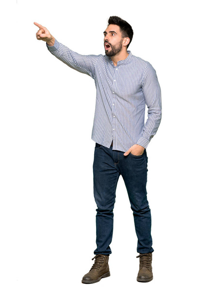 Tiro completo de homem elegante com camisa apontando para longe no fundo branco isolado
 - Foto, Imagem
