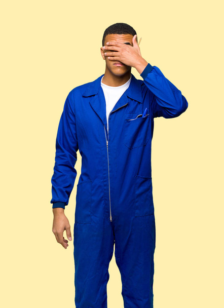 Young afro american worker man covering eyes by hands. Do not want to see something on isolated background - Photo, Image