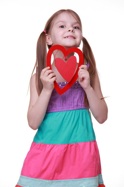 Little girl in a colorful dress posing with heart - Φωτογραφία, εικόνα