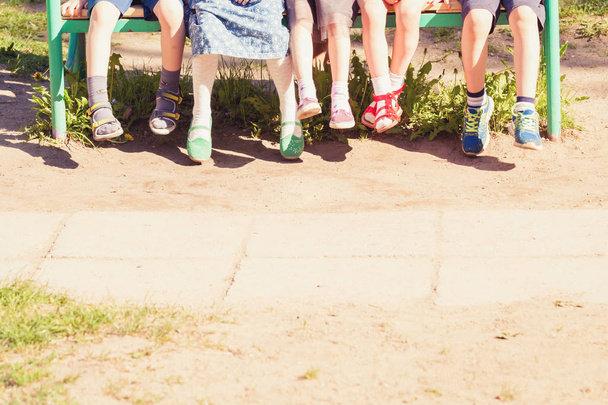 The children are sitting on a bench. Summer school holidays - Фото, зображення