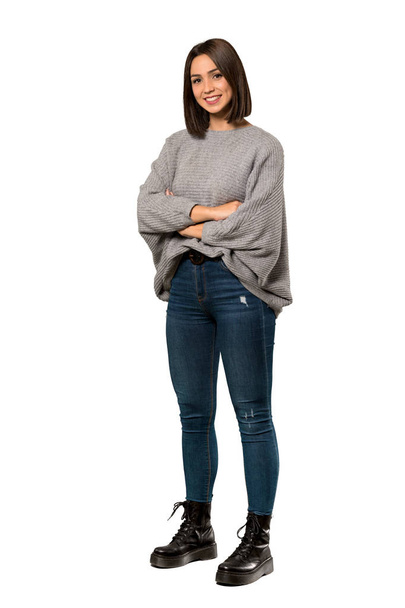 A full-length shot of a Young woman with arms crossed and looking forward over isolated white background - Photo, Image