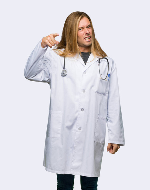 Doctor man frustrated by a bad situation and pointing to the front on isolated background - Photo, image