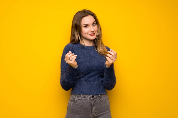 Dospívající dívka přes žlutou zeď peníze gesto - Fotografie, Obrázek