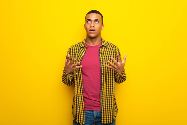 Young afro american man on yellow background frustrated by a bad situation - Photo, Image