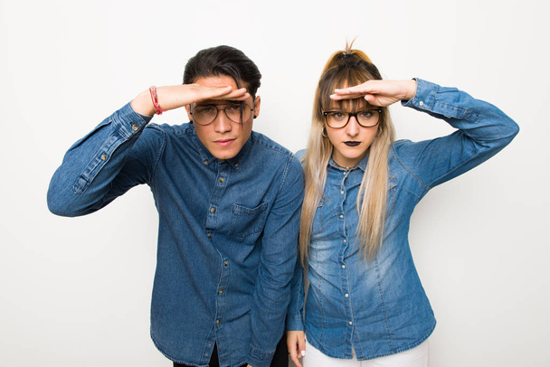 Young couple with glasses looking far away with hand to look something - Photo, Image