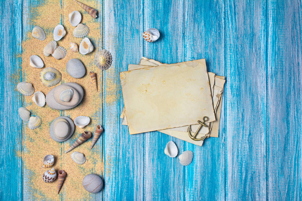 Top view on mock-up of vintage photo cards with sea stones and seashells on blue wooden background - Φωτογραφία, εικόνα
