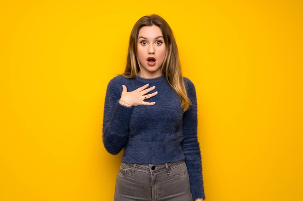 Teenager girl over yellow wall surprised and shocked while looking right - Photo, Image
