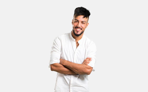 Hombre joven árabe con camisa blanca manteniendo los brazos cruzados sobre fondo gris
 - Foto, imagen