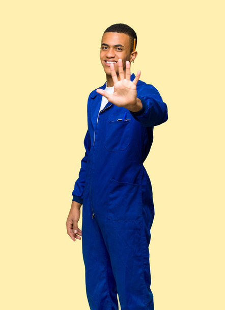 Ο άνθρωπος νέος afro Αμερικανός εργαζόμενος μετρώντας πέντε με τα δάχτυλα σε απομονωμένες φόντο - Φωτογραφία, εικόνα