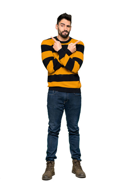 Celovečerní snímek pohledný muž s pruhovaný svetr, přejdete na příkaz přípojky s pochybnosti o izolované bílé pozadí - Fotografie, Obrázek